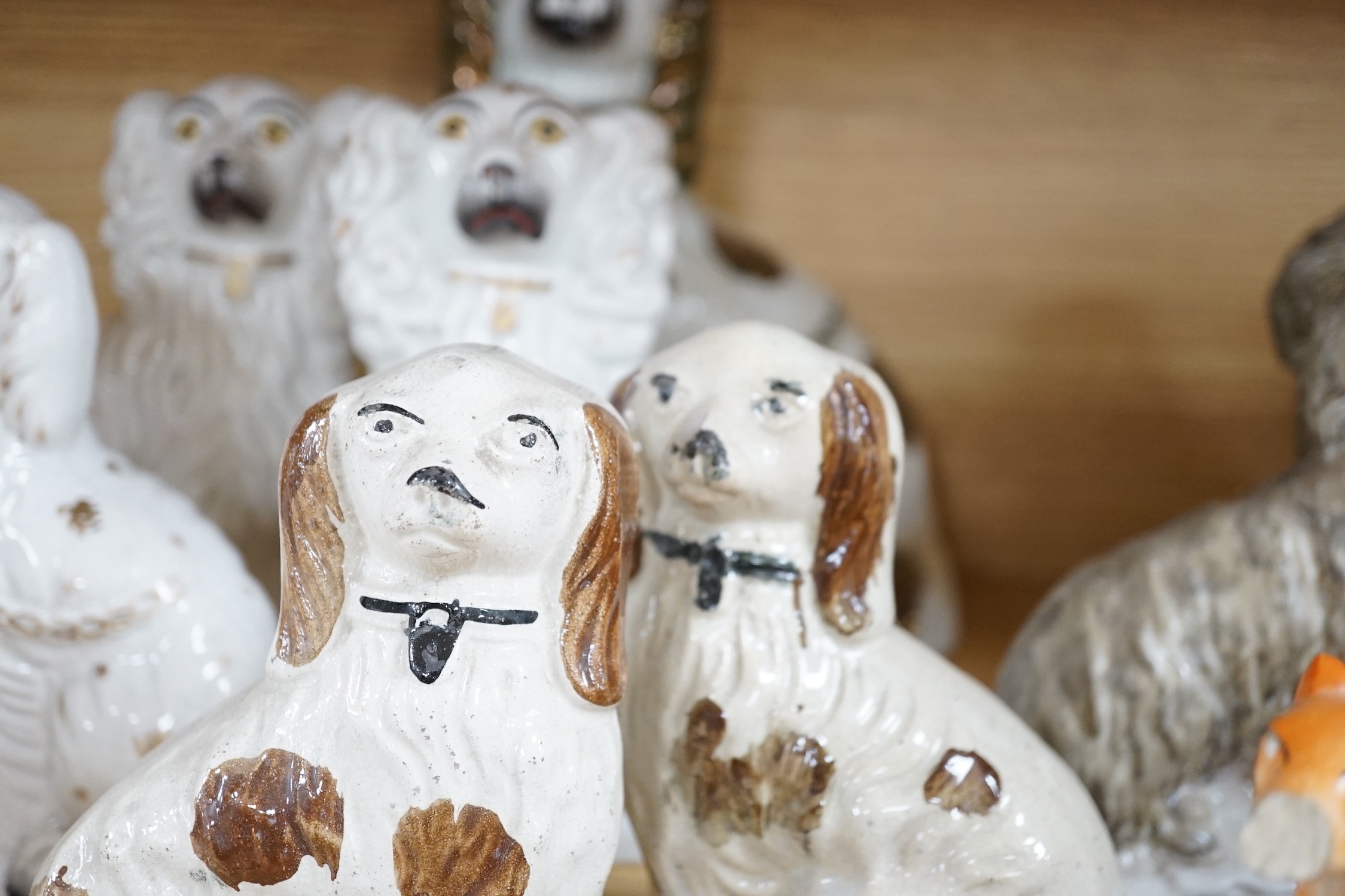 A mixed collection of mostly Staffordshire pottery models of recumbent dogs, hounds, etc. to include Dalmatians- 19.5cms high